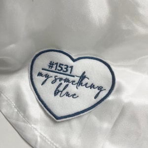 May include: White satin fabric with a blue heart-shaped patch that says "#1531 my something blue" in cursive.