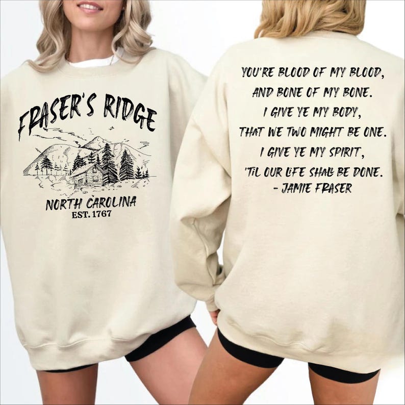 a woman wearing a white sweatshirt with text and graphics printed on it.
