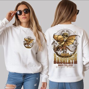 A woman wearing a white sweater with a graphic design of a dragon on the back.
