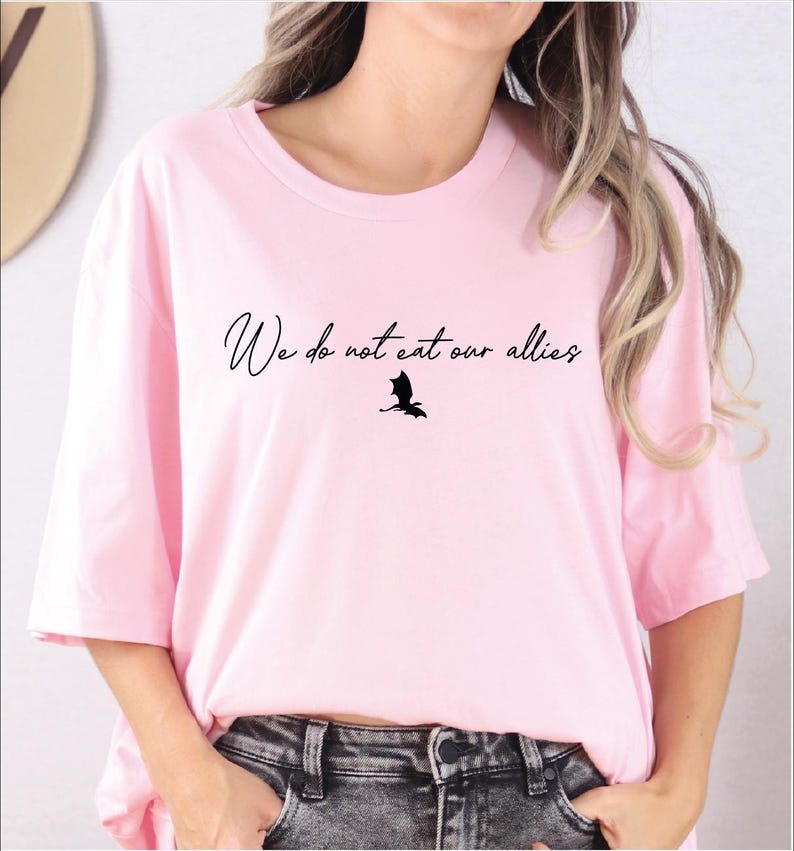 a woman wearing a pink shirt with a bird on it