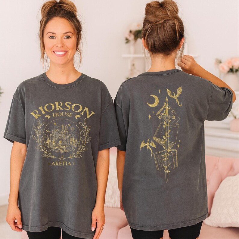 A woman wearing a gray t-shirt with a graphic design on the front and a back featuring a similar design.