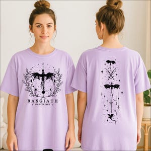 A woman wearing a purple t-shirt with a dragon design and text on it.
