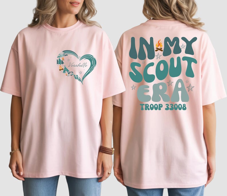 A woman wearing a pink t-shirt with a heart design and text on the back.