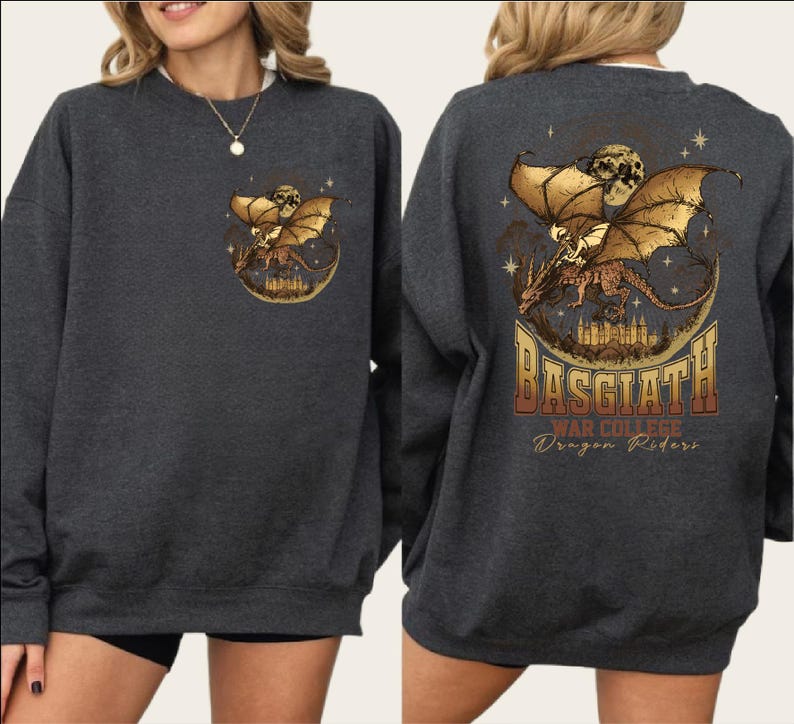 a gray sweatshirt with a graphic design on the back. The design depicts a dragon and a castle, with the text "BASGIATH Dragon Riders" written below the dragon.