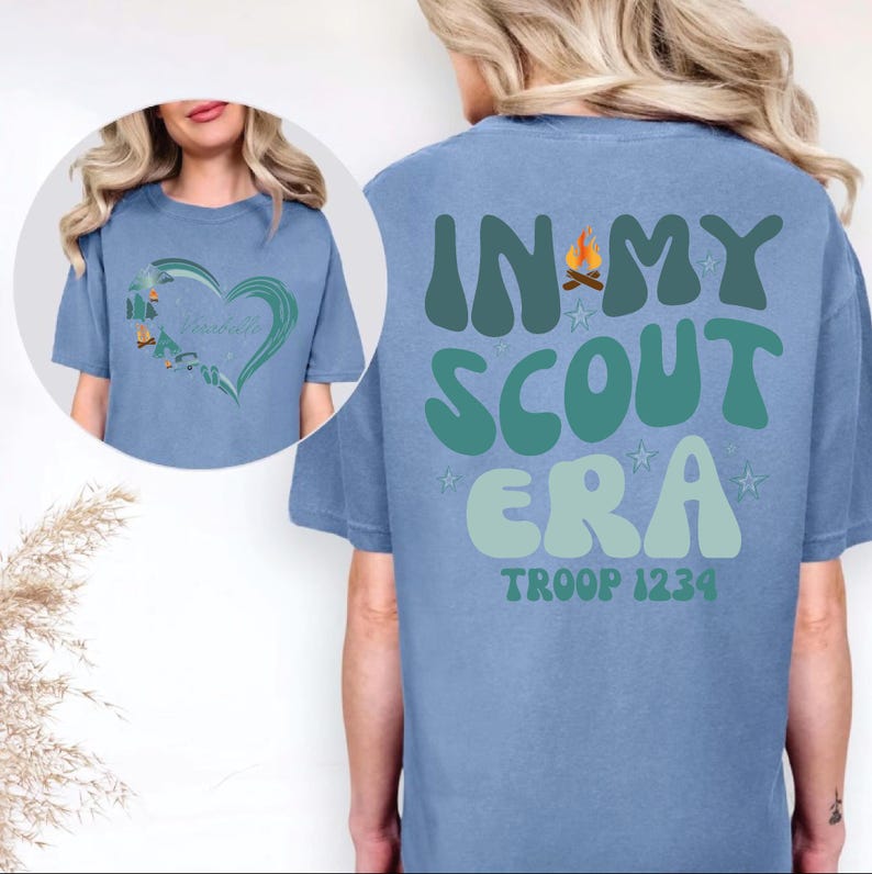 A woman wearing a blue t-shirt with the text "IN MY SCOUT ERA" printed on it.