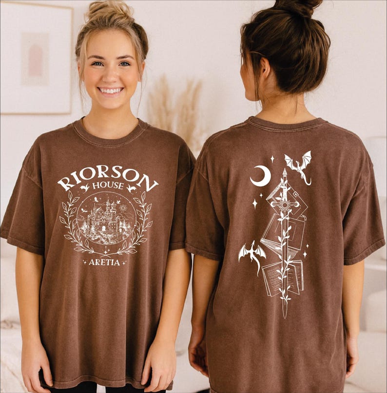 A woman wearing a brown t-shirt with a graphic design on the front and back.