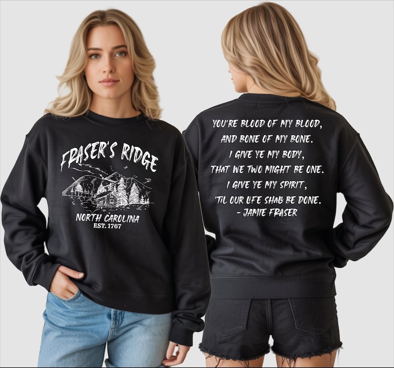 A woman wearing a black sweatshirt with text and graphics printed on it.