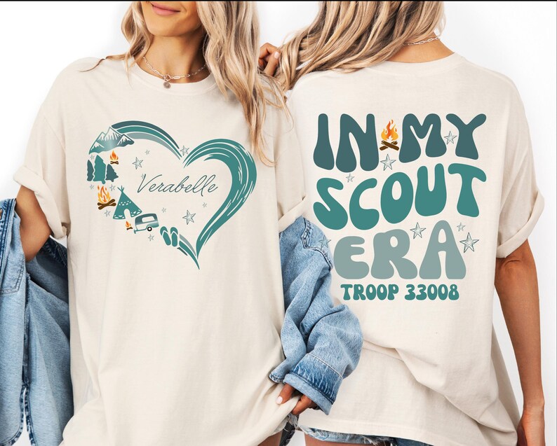 two women wearing white t-shirts with text and graphics printed on them.