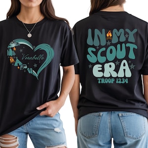 A black t-shirt with a graphic design and text on the back, and a person wearing the t-shirt.