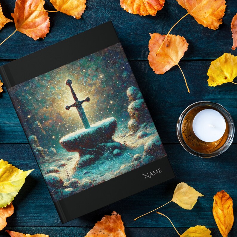 May include: A black hardcover journal with a fantasy illustration of a sword in a stone. The illustration is set against a starry night sky and features a snowy landscape. The journal has the word "NAME" printed on the cover.
