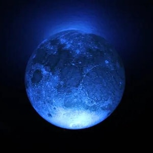 May include: A blue moon lamp with a realistic moon surface texture. The lamp is lit up, casting a soft blue glow.