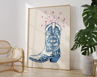 May include: A blue and white cowboy boot with a floral design, filled with pink flowers. The boot is on a cream background.