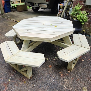 May include: Octagonal wooden picnic table with four benches. The table and benches are made of unfinished light wood.