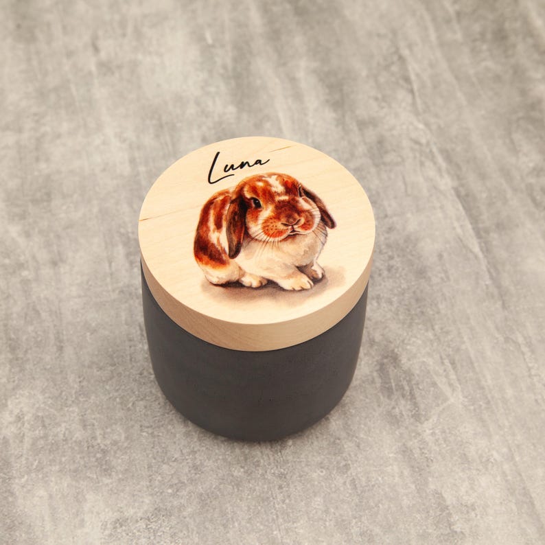 A ceramic container with a lid featuring a painting of a rabbit.