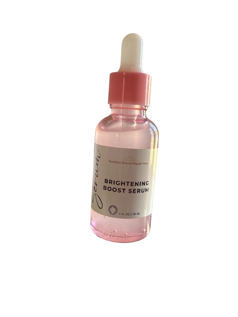 Pu&ograve; includere: Una bottiglia di vetro trasparente con un contagocce e un tappo rosa. La bottiglia contiene un siero etichettato "BRIGHTENING BOOST SERUM" e "1 FL OZ | 30 ML".