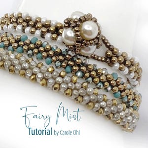 Puede incluir: Una pulsera de cuentas de varias hebras con cuentas blancas, doradas metálicas y verde azulado, con un grupo central de perlas color crema. El texto "Fairy Mist Tutorial by Carole Ohl" aparece en la esquina inferior izquierda.