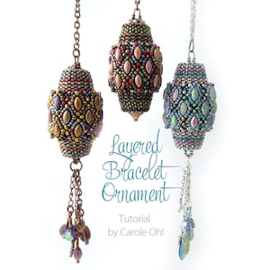 Może przedstawiać: Trzy koralowe ozdoby z warstwowymi wzorami w odcieniach brązu, miedzi i błękitu. Każda ozdoba ma łańcuszek i frędzle z koralików. Tekst "Layered Bracelet Ornament" jest napisany ozdobnym fontem pod ozdobami.