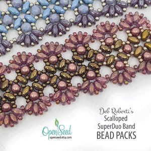 May include: Close-up of beaded bands in shades of blue, purple, and pink. The bands feature a scalloped design with small, round beads and larger, petal-shaped beads. The text "Deb Roberti's Scalloped SuperDuo Band BEAD PACKS" is visible.