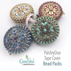 May include: Four intricately beaded tape measure covers in gold, purple, blue, and teal. Each cover features a unique floral design with a central embellishment. A white and red measuring tape extends from one cover. Text on the image reads "PaisleyDuo Tape Cover Bead Packs."
