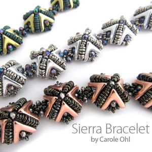 May include: A close-up of a silver, copper, and gold beaded bracelet with a geometric design. The bracelet is called "Sierra Bracelet" by Carole Ohl.