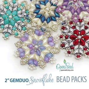 May include: A collection of five handcrafted snowflake ornaments made from various colored GemDuo beads, including turquoise, silver, blue, purple, and red, accented with small white seed beads. Text reads 2" GEMDUO Snowflake BEAD PACKS.