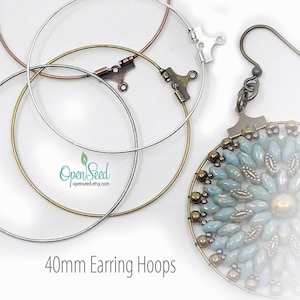 May include: An assortment of 40mm earring hoops in copper, silver, and gold tones, with a beaded earring featuring blue and gold beads. The image includes the text "40mm Earring Hoops" and the Open Seed logo.