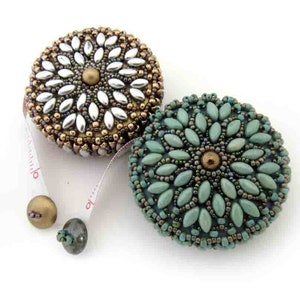 May include: Two beaded measuring tapes, one with a silver and gold design and the other with a teal and gold design.