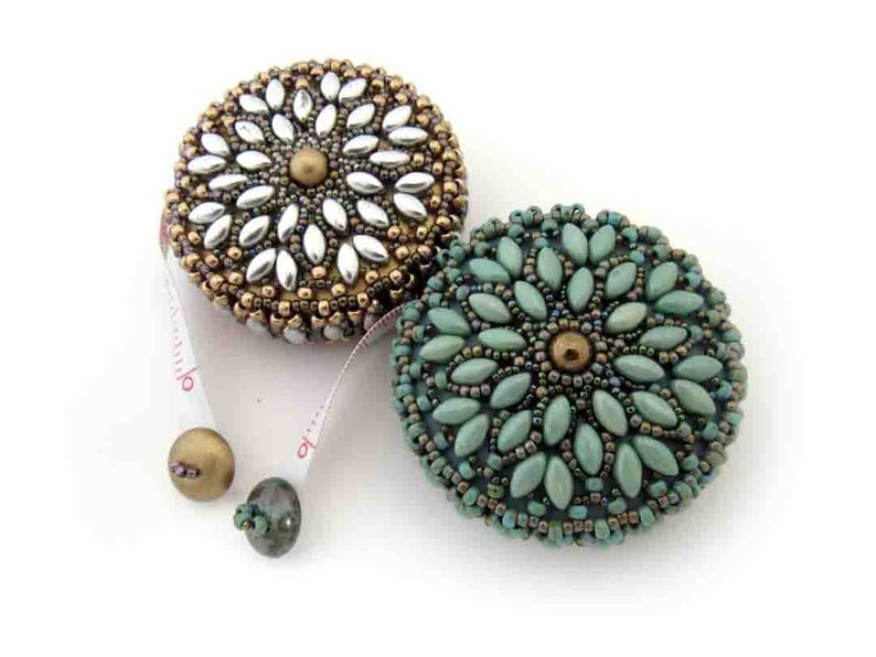 May include: Two beaded measuring tapes, one with a silver and gold design and the other with a teal and gold design.