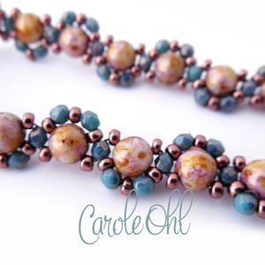 Könnte beinhalten: Nahaufnahme eines Armbands mit Perlen und floralem Design. Das Armband hat große, gesprenkelte, pfirsichfarbene Perlen, die von türkis- und kupferfarbenen Perlen umgeben sind. Das Design wiederholt sich entlang des Armbands.