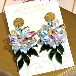 May include: A pair of blue and white floral earrings with green leaves. The earrings are made of acrylic and have a gold glitter accent. The earrings are labelled "Elise Gage Coastal Frippery" and "Digital File Only".