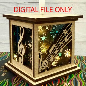 May include: A wooden lantern with a musical theme. The lantern features cut-out designs of musical notes and a treble clef, with a starry background. The text "DIGITAL FILE ONLY" is visible on the top. The lantern is illuminated with small lights.