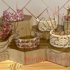 Puede incluir: Seis pulseras de plástico blanco, con diferentes patrones y lisas, expuestas en soportes hexagonales de madera. Las pulseras tienen varios diseños florales y geométricos. Los soportes están dispuestos en forma de pirámide. El texto "FRIPPERY DIGITAL FILE ONLY" es visible en los soportes.