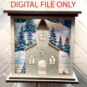 May include: A wooden night light shaped like a church, featuring a winter scene with snow-covered trees and mountains. The text "DIGITAL FILE ONLY" is displayed at the top. The church has cut-out windows and a cross-shaped design on the roof.