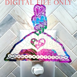 May include: A decorative night light featuring a hanger design with a heart-shaped cutout. The hanger is adorned with a colorful, swirling pattern in shades of pink, blue, and green. The text "S W I F T I E" is displayed along the bottom edge.