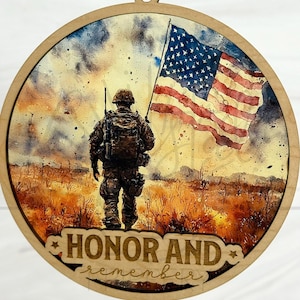 May include: Round wooden ornament featuring a watercolor image of a soldier carrying the American flag. The text "DIGITAL FILE ONLY" is at the top. The words "HONOR AND remember" are at the bottom.