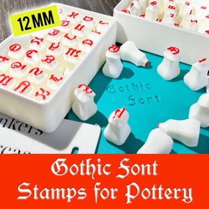 Puede incluir: Sellos blancos de fuente gótica para cerámica, con tinta roja, se muestran en recipientes blancos. El texto "Gothic Font Stamps for Pottery" es visible. Los sellos miden 12 mm.