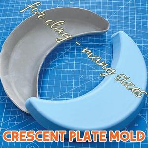 May include: Two crescent-shaped plate moulds, one grey and one light blue, are displayed on a blue grid surface. The text "for clay - many sizes" is written in a cursive font. The words "CRESCENT PLATE MOLD" are written in orange block letters.