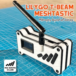 Könnte beinhalten: Ein weißes und schwarzes LILYGO T-BEAM MESH TASTIC Gerät mit einer schwarzen Antenne. Das Gerät hat einen kleinen Bildschirm und schwarze Tasten. Der Text auf dem Gerät lautet "Messaging beyond cell coverage" und "NO BARS CLUB".