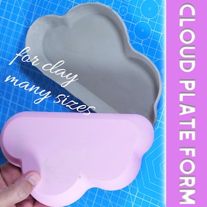 Op de afbeelding: Twee wolkvormige platforms, één grijs en één roze, worden getoond. Het grijze platform is boven het roze geplaatst. Tekst op de afbeelding luidt "for clay many sizes" en "CLOUD PLATE FORM". De platforms staan op een blauw oppervlak.