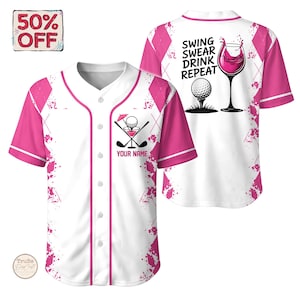 Pode incluir: Camisola de baseball branca com mangas e detalhes em rosa. Apresenta um design com tema de golfe com uma bola de golfe, um cocktail e tacos de golfe cruzados. A parte de trás diz "SWING SWEAR DRINK REPEAT" com uma bola de golfe e taça de vinho.