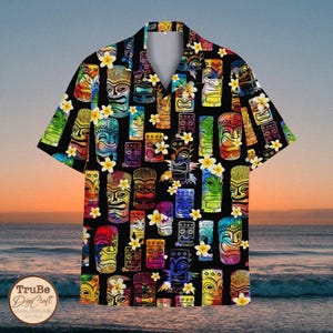 May include: A black button-up shirt with a colourful Hawaiian print featuring tiki faces and yellow flowers.