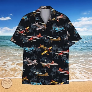 May include: A black button-up shirt with a tropical print featuring vintage airplanes and palm trees. The shirt has a relaxed fit and short sleeves.
