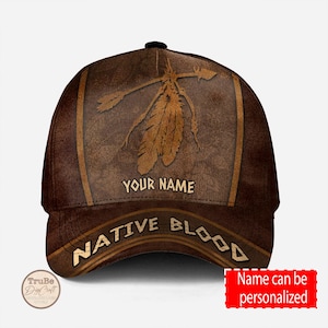 Puede incluir: Gorra de béisbol de cuero marrón con un diseño de plumas nativo americano y el texto "Native Blood" y "Your Name".