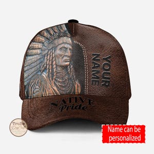 Puede incluir: Gorra de béisbol de cuero marrón con una imagen de un jefe nativo americano y el texto "NATIVE PRIDE" en la parte delantera. El lateral de la gorra tiene el texto "YOUR NAME".