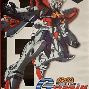 Puede incluir: Caja de DVD de la serie de anime Mobile Fighter G Gundam. La portada presenta una ilustración detallada de un robot Gundam en rojo, blanco, azul y amarillo. El texto incluye "G Gundam" y "Complete TV Series".