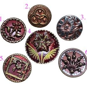 May include: A collection of six antique buttons in various designs. The buttons feature floral and geometric patterns in shades of red, brown, and gold. Each button has a unique embossed design, showcasing intricate details and textures. These vintage buttons are perfect for sewing and crafting projects.