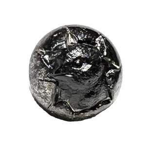 May include: A dark, metallic-looking round object with a textured surface. The object appears to be a coin or a similar small, round item. The surface has an embossed design, possibly a bust or a profile.