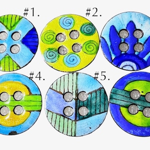 May include: Six round buttons labeled #1 through #6. Button #1 has blue and green geometric patterns. #2 is yellow with blue swirls. #3 features blue petals. #4 has yellow and green bands. #5 shows blue and green stripes. #6 has a green center.