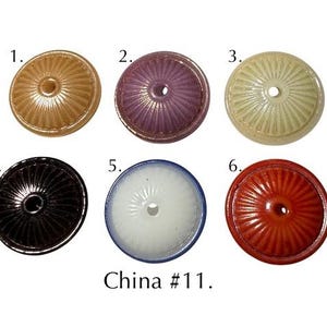 Könnte beinhalten: Sechs runde, gewölbte Perlen mit einem Mittelloch und radialer Rippenstruktur, nummeriert von 1 bis 6. Die Farben umfassen Beige, Violett, Creme, Schwarz, Weiß mit blauem Rand und Rot. Der Text China #11 ist unten im Bild aufgedruckt.