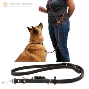 a black leather leash is shown both on a white background and with a person who wears the leash over-the-shoulder cross body. The person has one hand behind their back. The leash is attached to a sable dog who looks up at the person.